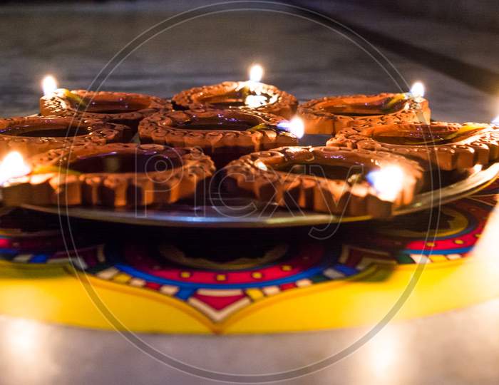 Happy Diwali - Colorful clay diya lamps lit during diwali celebration