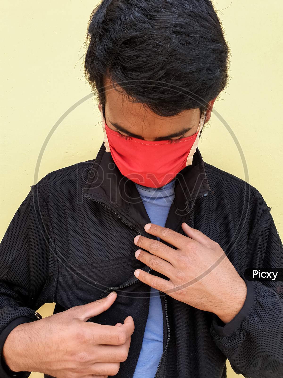 capture of a young indian man wearing a face mask to protect against the coronavirus during lockdown with selective focus, selective focus on subject, background blur