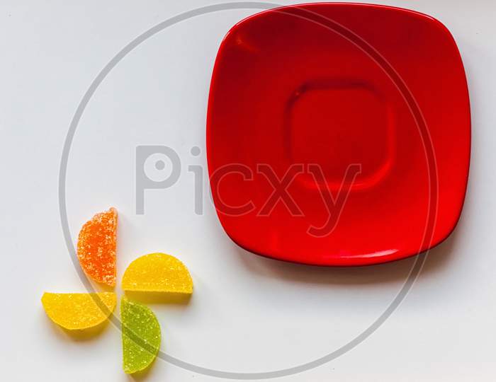 Four Sugar Candies And Red Plate