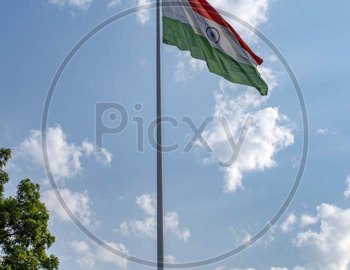 Indian National Flag Hoisted In The Blue Cloudy Sky On 74Th Indian Independence Day