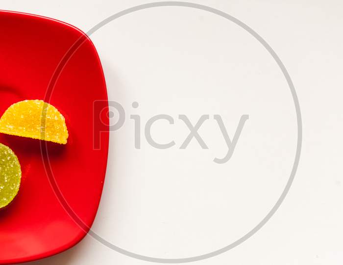 Two Sugar Candies On A Red Plate