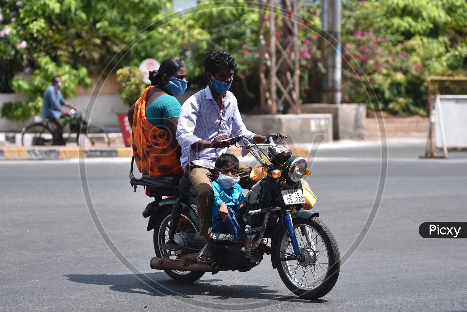 A Family Wearing Protective Face Masks Travel On A Two-Wheelerduring The Nationwide Lockdown Amid Coronavirus Pandemic In Vijayawada.
