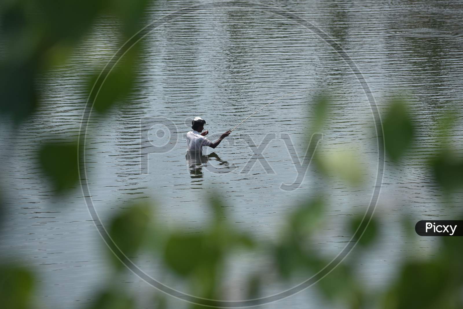 A Local Catches Fish At The Rivas Canal During The Nationwide Lockdown Amid Coronavirus Pandemic In Vijayawada.