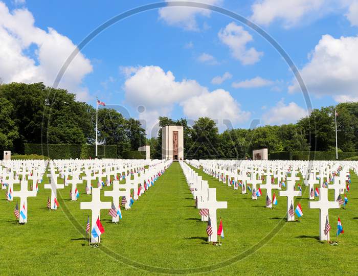 Rows Of Headstones At A Military Cemetery With A Chapel In The Backgound