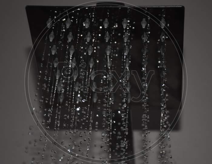 Closeup of a shower head with sprinkling or splashing water
