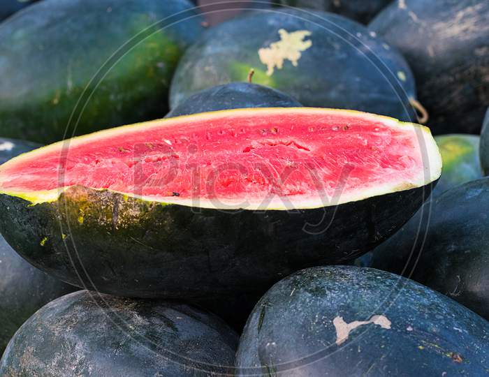 Red Cut Watermelon On A Pile Of Ripe Watermelons