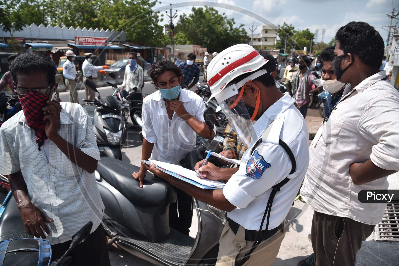 Traffic Police Personnel Stops The Commuters And Seeks An Explanation For Violating The Lockdown Norms During The Nationwide Lockdown Amid Coronavirus Pandemic In Vijayawada.