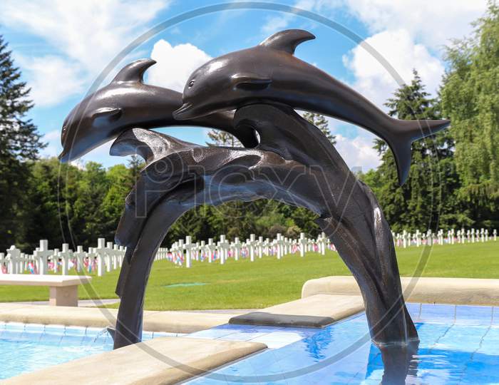 Dolphin Statue In A Fountain In A Military Cemetery