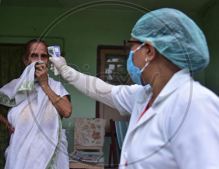 A Health Worker Checks The Temperature Of A Older Women  As She Conducts House To House Health Survey During Nationwide Lockdown Amidst Coronavirus or COVID-19 Pandemic  In Nagaon District Of Assam,India