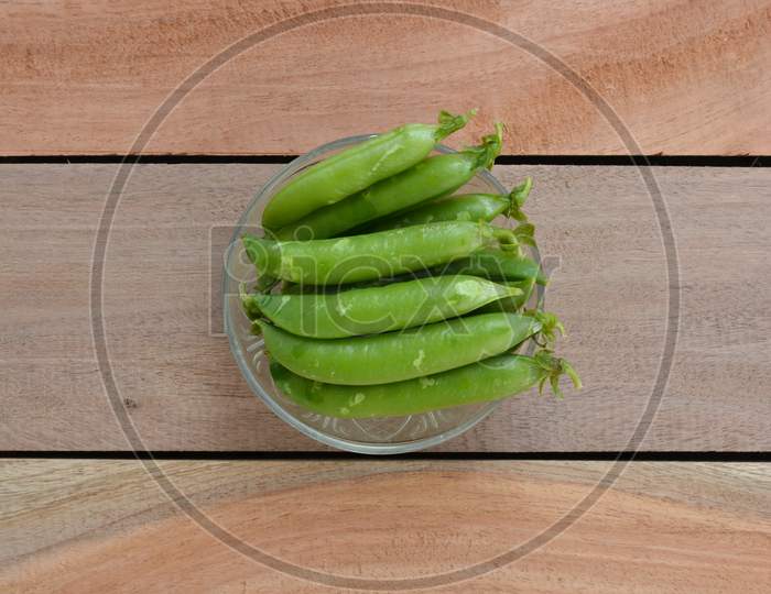 Fresh green peas on wooden background