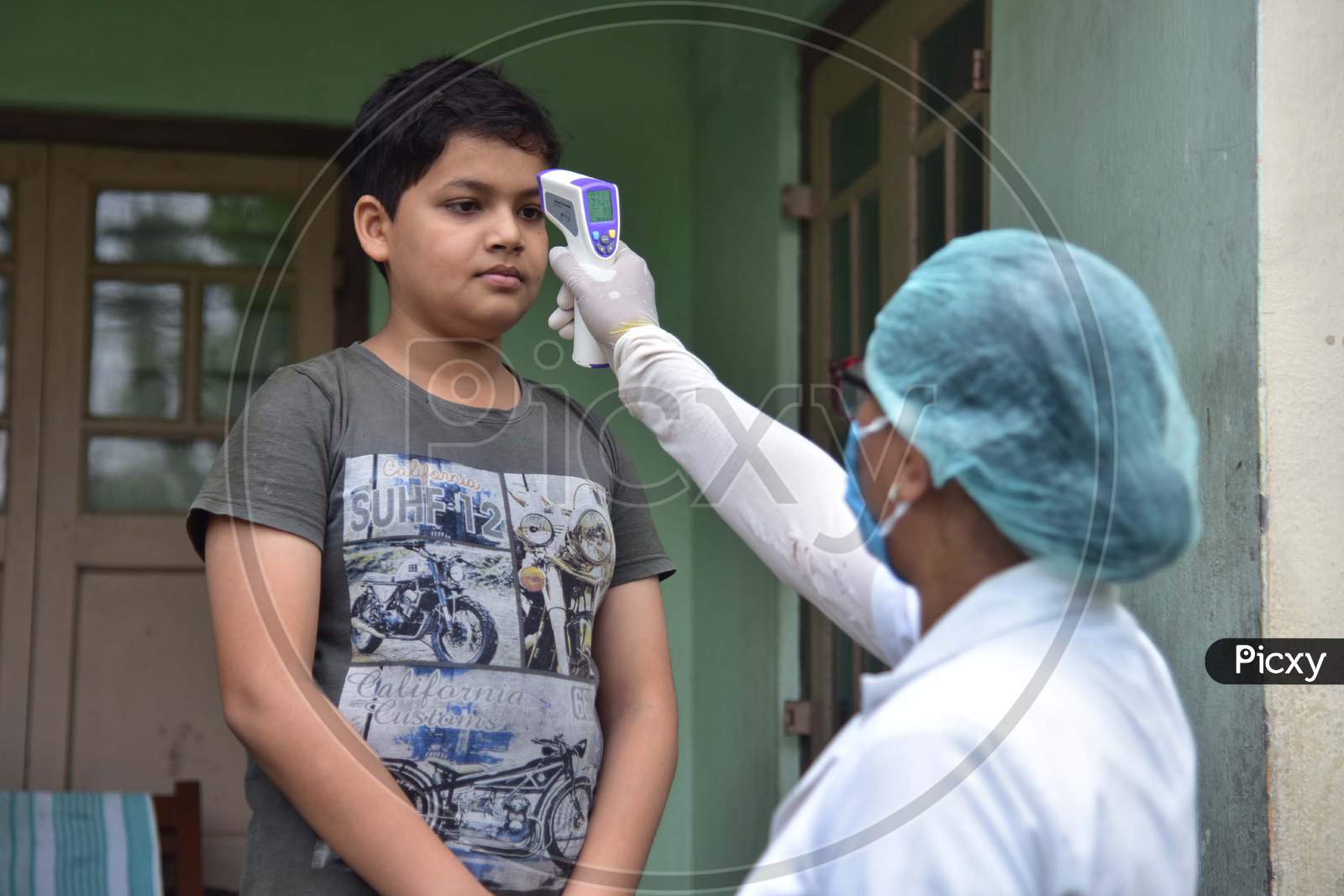 A Health Worker Checks The Temperature Of A Boy As She Conducts House To House Health Survey During Nationwide Lockdown Amidst Coronavirus or COVID-19 Pandemic  In Nagaon District Of Assam,India
