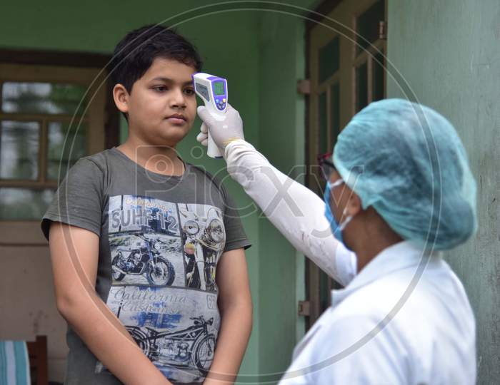 A Health Worker Checks The Temperature Of A Boy As She Conducts House To House Health Survey During Nationwide Lockdown Amidst Coronavirus or COVID-19 Pandemic  In Nagaon District Of Assam,India