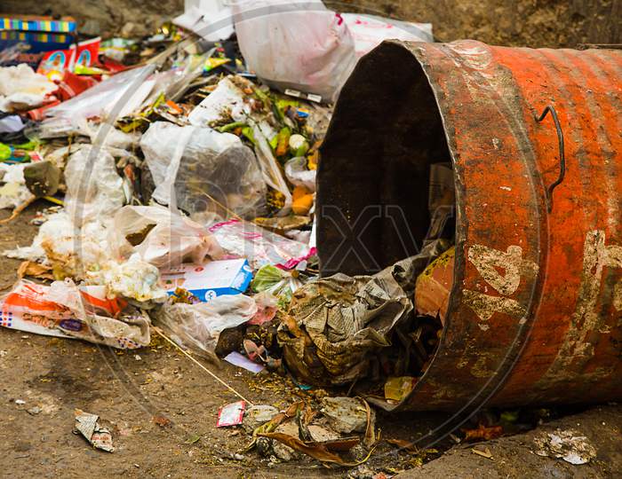Jodhpur, Rajasthan, India, December 25, 2018: Littering Waste Trash That Have Been Disposed Improperly Around Dust Bin. Garbage Can Is Full. Trash Is Fallen On The Ground. - Image