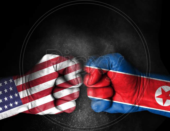 Conflict Between Usa And North Korea, Male Fists With Flags Painted On Skin Isolated On Black Background - Governments Conflict Concept