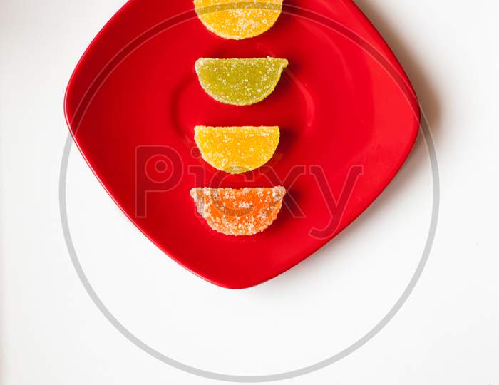 Four Sugar Candies On A Red Plate