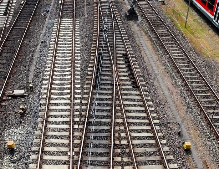 Railroad tracks and signs with junctions at a railway station in a perspective view