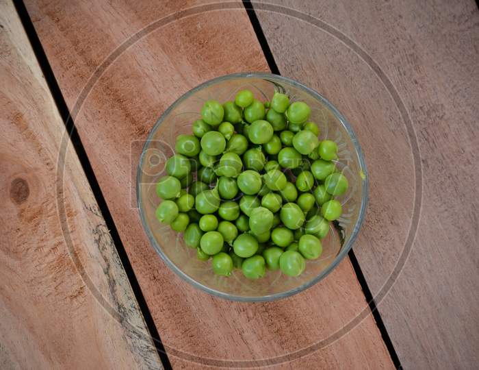 Fresh green peas in a glass bowl