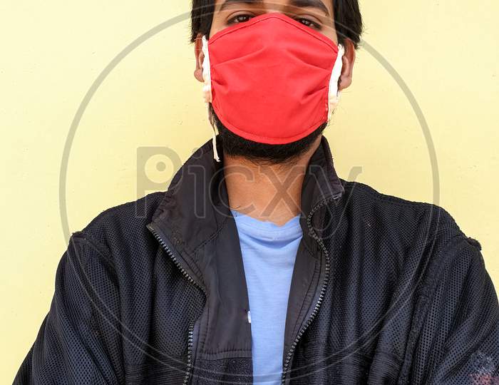 closeup of a young indian guy wearing a face mask to protect against the coronavirus during lockdown