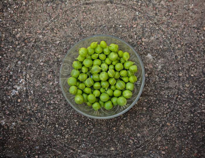 Fresh green peas in a glass bowl