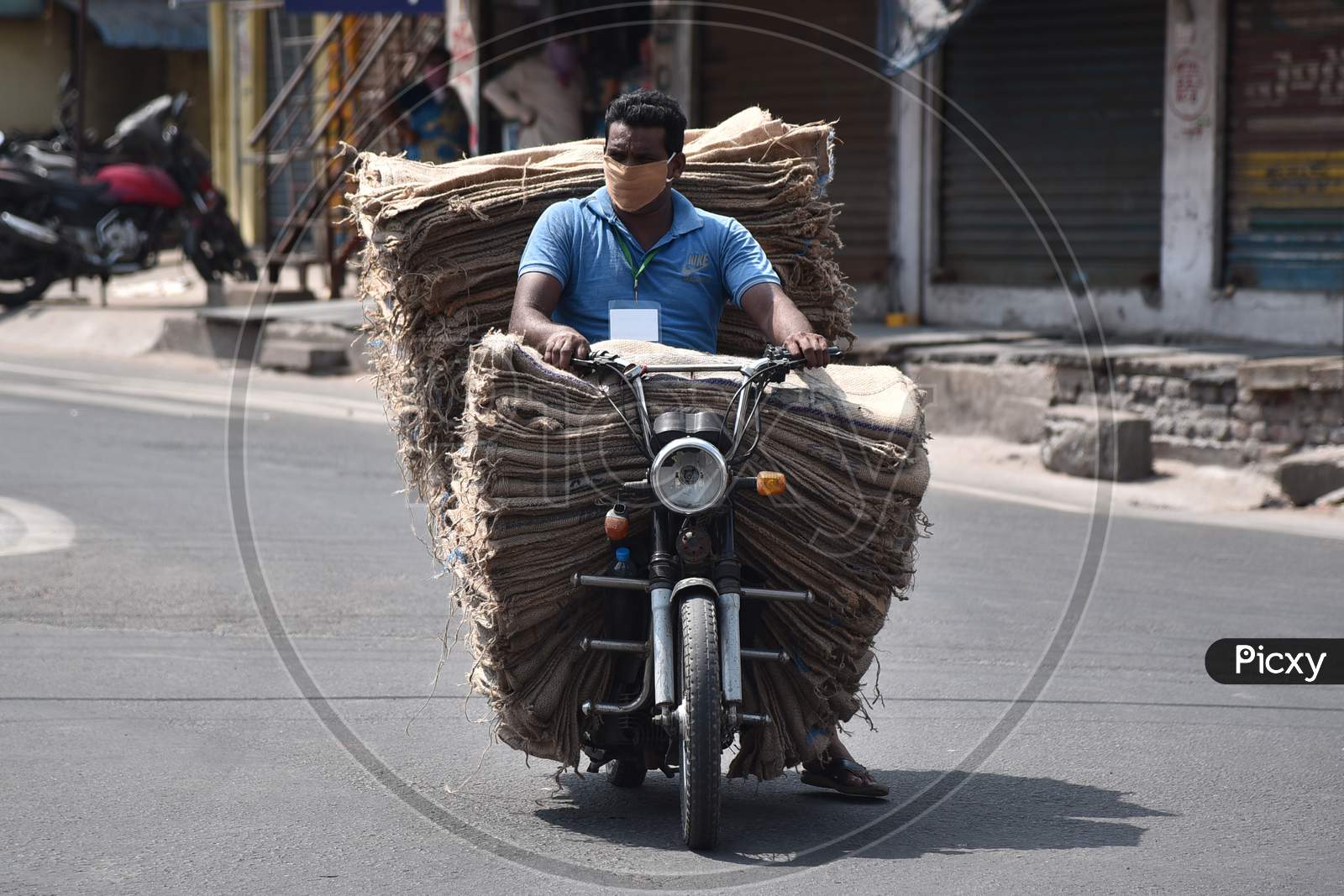 A Man Carries A Pile Of Gunny Bags On A Two-Wheeler During The Nationwide Lockdown Amid Coronavirus Pandemic In Vijayawada.