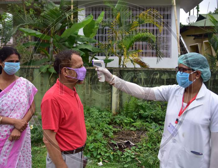 A Health Worker Checks The Temperature Of A Man As she Conducts House To House Health Survey During Nationwide Lockdown Amidst Coronavirus or COVID-19 Pandemic  In Nagaon District Of Assam,India