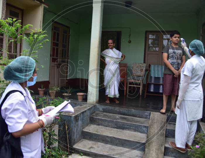 A Health Worker Checks The Temperature Of A boy As she Conducts House To House Health Survey During Nationwide Lockdown Amidst Coronavirus or COVID-19 Pandemic  In Nagaon District Of Assam,India