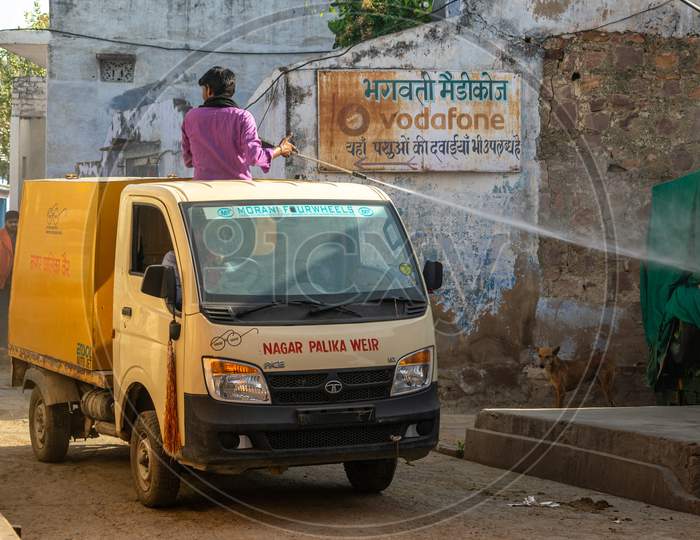 A man on Nagar palika municipality vehicle sprays Disinfectants amid concerns over coronavirus or covid 19
