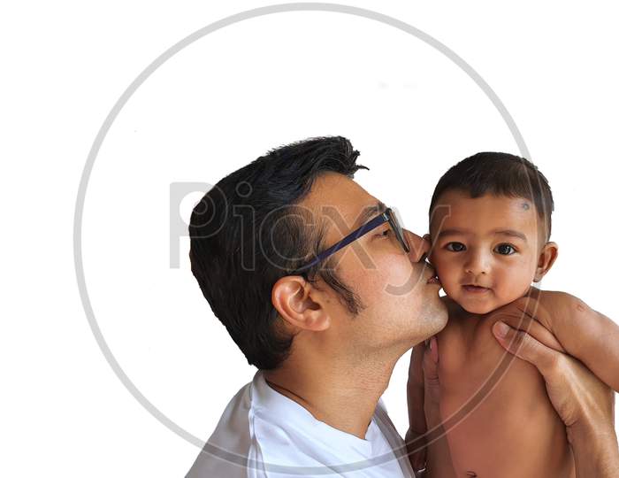 A Father In Glasses Kissing A Little Boy On His Lap In White Background