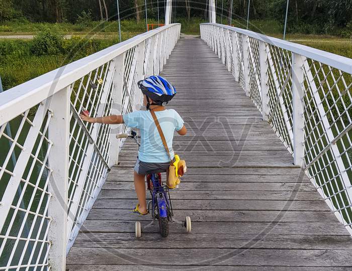 A Boy With Bicycle On A Bridge, Touches A Bridge.