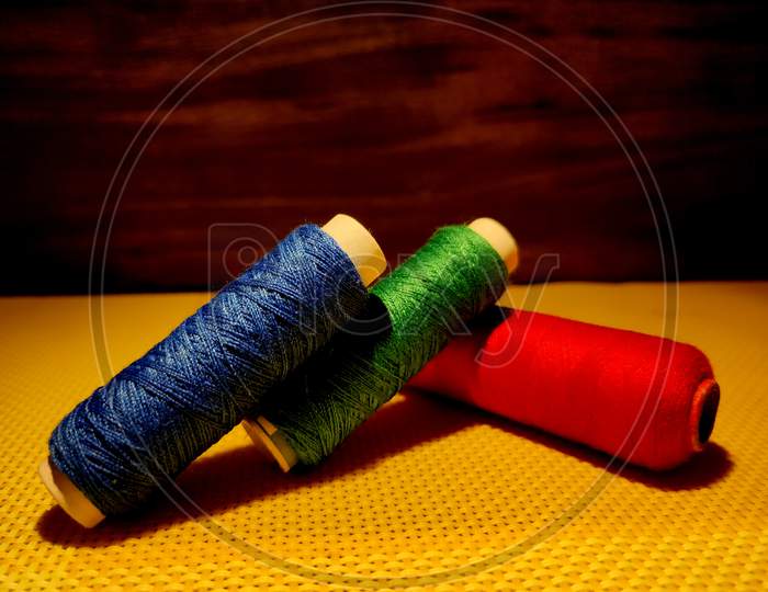 Multi color Sewing Threads With Dark Background.