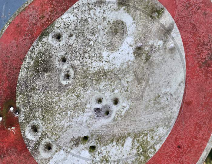 Several bullet holes in a traffic sign used for gun shooting exercises