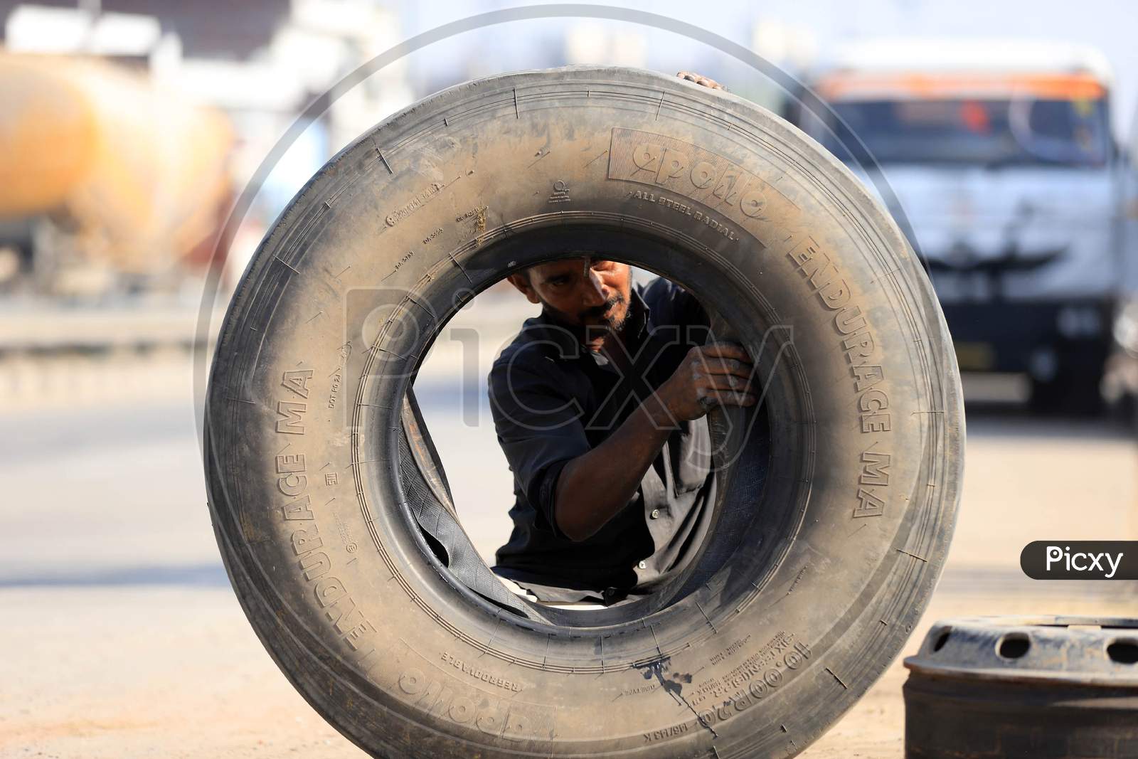 A Man Repairing Truck Tyre  at a Road Side Shop  During Extended Nationwide Lockdown Amidst Coronavirus Or COVID-19 Pandemic in Prayagraj