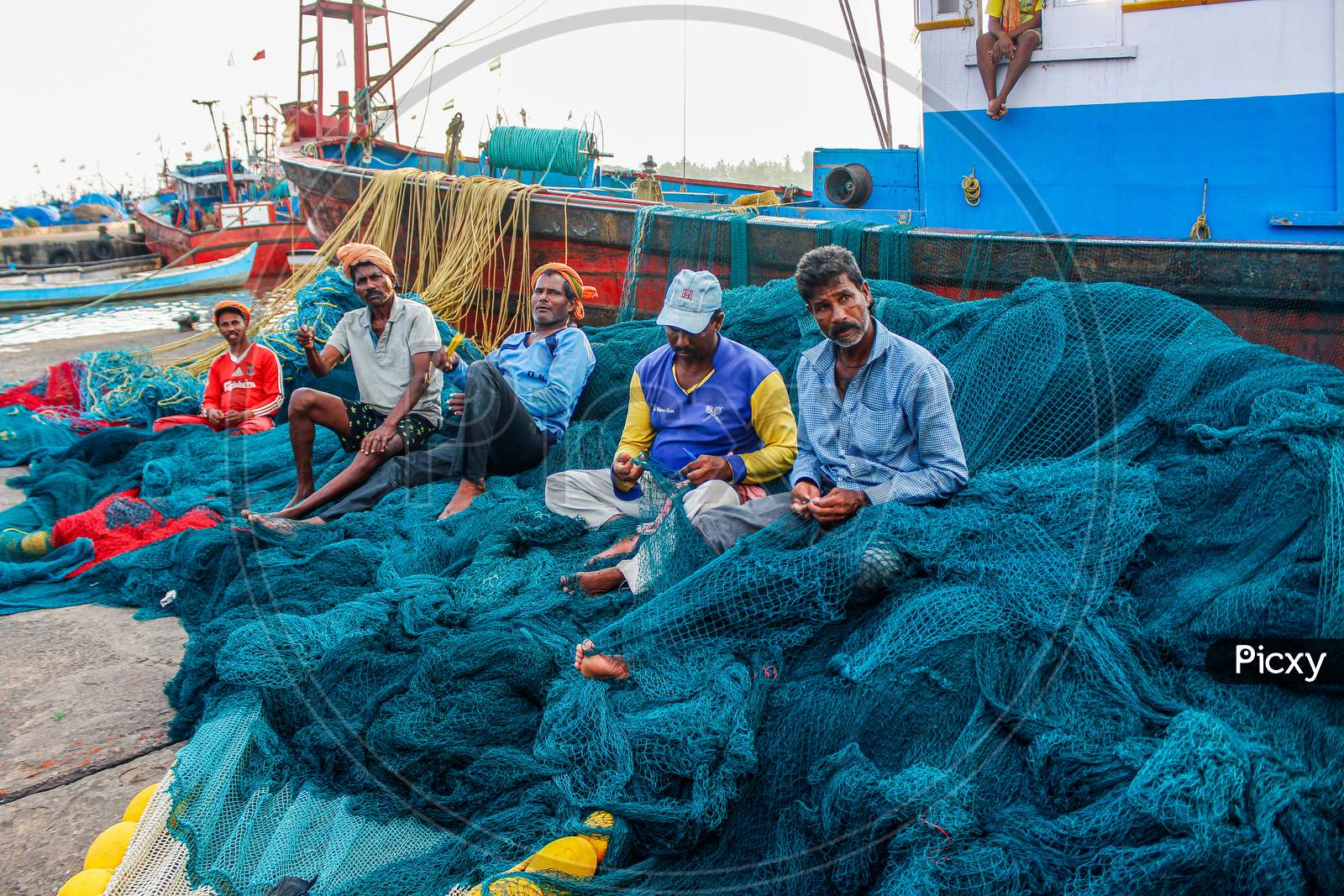 fisherman working on nets in fishery port old mangalore port