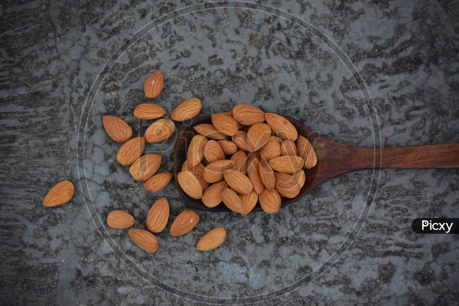 Dried almond nuts in wooden spoon