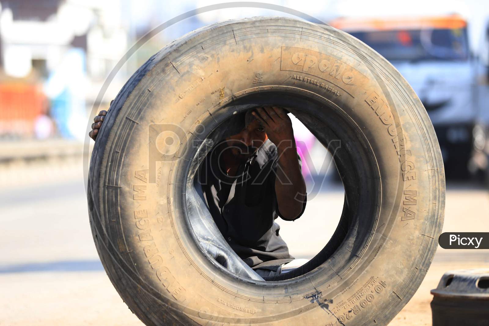 A Man Repairing Truck Tyre  at a Road Side Shop  During Extended Nationwide Lockdown Amidst Coronavirus Or COVID-19 Pandemic in Prayagraj