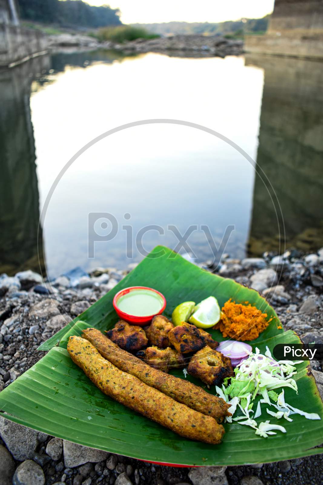 Seekh kebab on banana leaf in river bank, top view