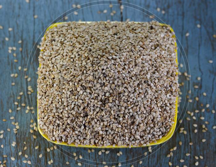 Sesame seeds in bowl on wooden background