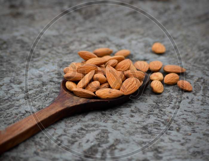 Dried almond nuts in wooden spoon