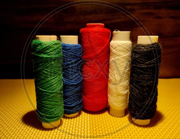 Multi color Sewing Threads With Dark Background.