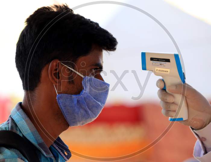 A Health Worker Uses A Thermal Screening Device On A Pilgrim Before He Boards A Train For Uttar Pradesh At Ajmer Railway Station, During A Government-Imposed Nationwide Lockdown As A Preventive Measure Against The Coronavirus, In Ajmer, Rajasthan, India On  May 17, 2020.