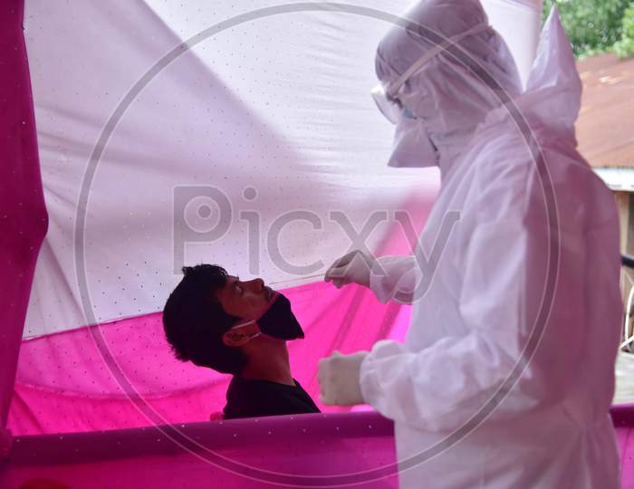 A Medic Collects A Swab Sample Of A Migrant Who Arrived From Chennai Via Shramik Special Train During Nationwide Lockdown Amidst Coronavirus or COVID-19 Pandemic  In Nagaon District Of Assam,India