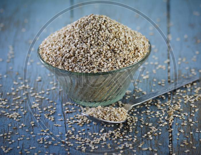 Sesame seeds in glass bowl on wooden background