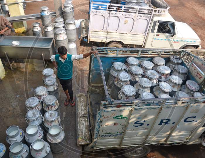 INDIA, UTTAR PRADESH, ETAWAH -  FEB 2019 Individually numbered milk cans filled with raw milk are being unloaded from a mini truck at milk chilling centre.