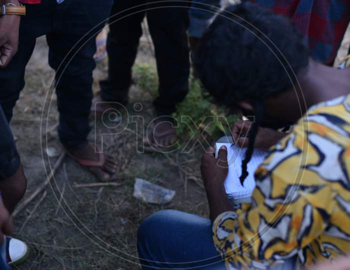 A Migrant worker writes down the names and phone numbers in a paper to get permission to travel till their native states.