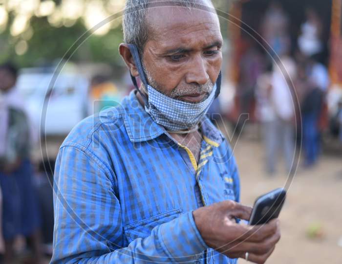 a migrant worker from Bihar talks with his family over a phone as he waits for clearance to move during an extended Lockdown amid coronavirus fears, May 16,2020