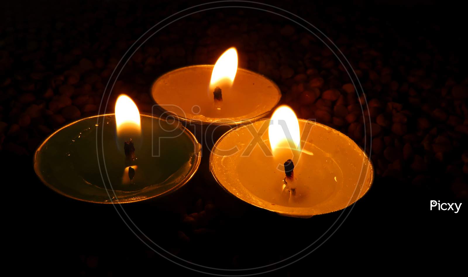 Candles on Split pea background,Isolated Green,Yellow And White candles on the seeds,Burning Candles.isolated temple candles.