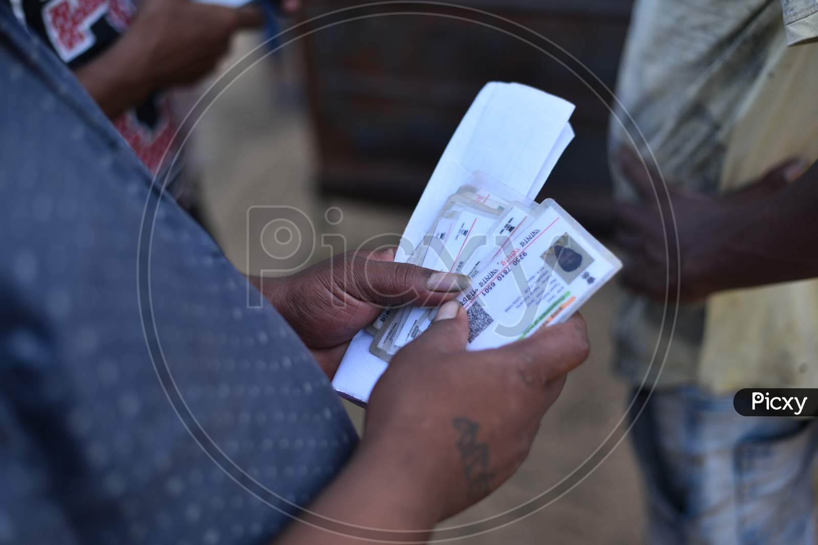 a migrant worker carries Aadhar cards of his colleagues