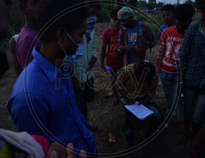 Migrant workers from Bihar write down their names and aadhar details in a paper in order to get permission to travel to their state at Telangana-Andhra Pradesh border, Aswaraopet,Telangana, 16 May, 2020