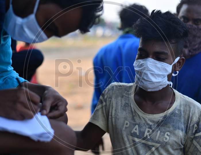 Migrant workers from West Bengal and Bihar write down their Aadhar details in a paper as they wait for permission to cross Telangana State at a Checkpost in Aswaropeta during an extended lockdown amid coronavirus fears, May 16,2020.