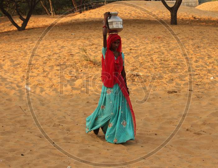 Rajasthani Woman Carrying Water Vessel Over Head At Dessert Villages of Rajasthan